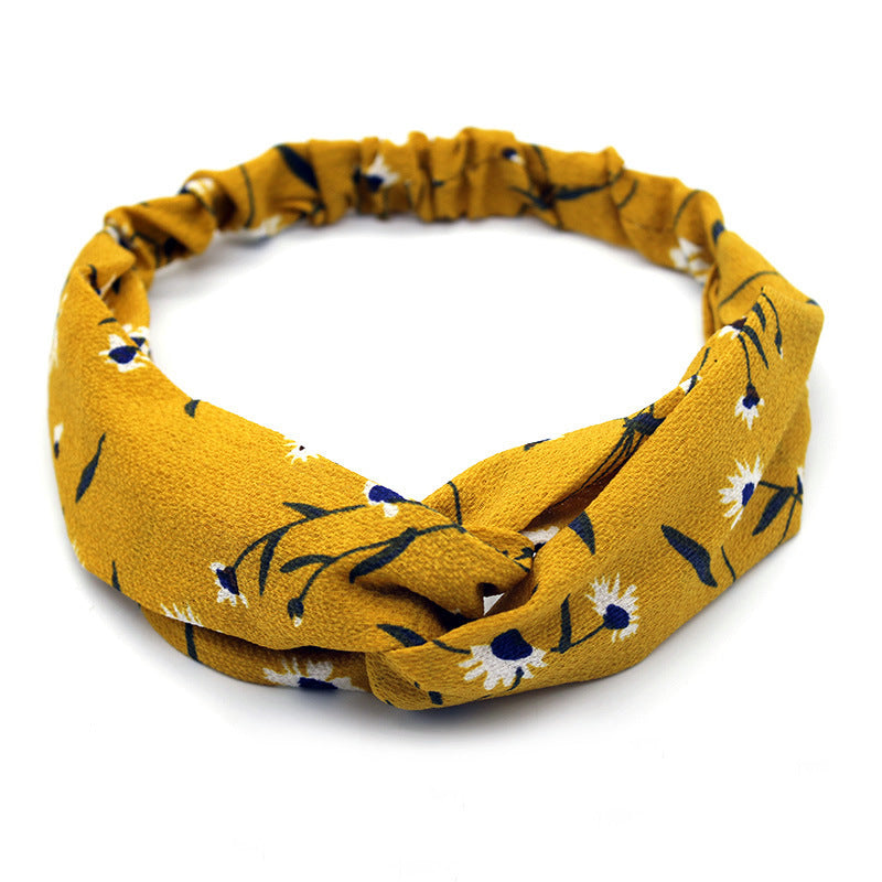 Ladies cross-knotted wide-brimmed headband with a fabric flower, perfect for adding a stylish and elegant touch to any outfit.