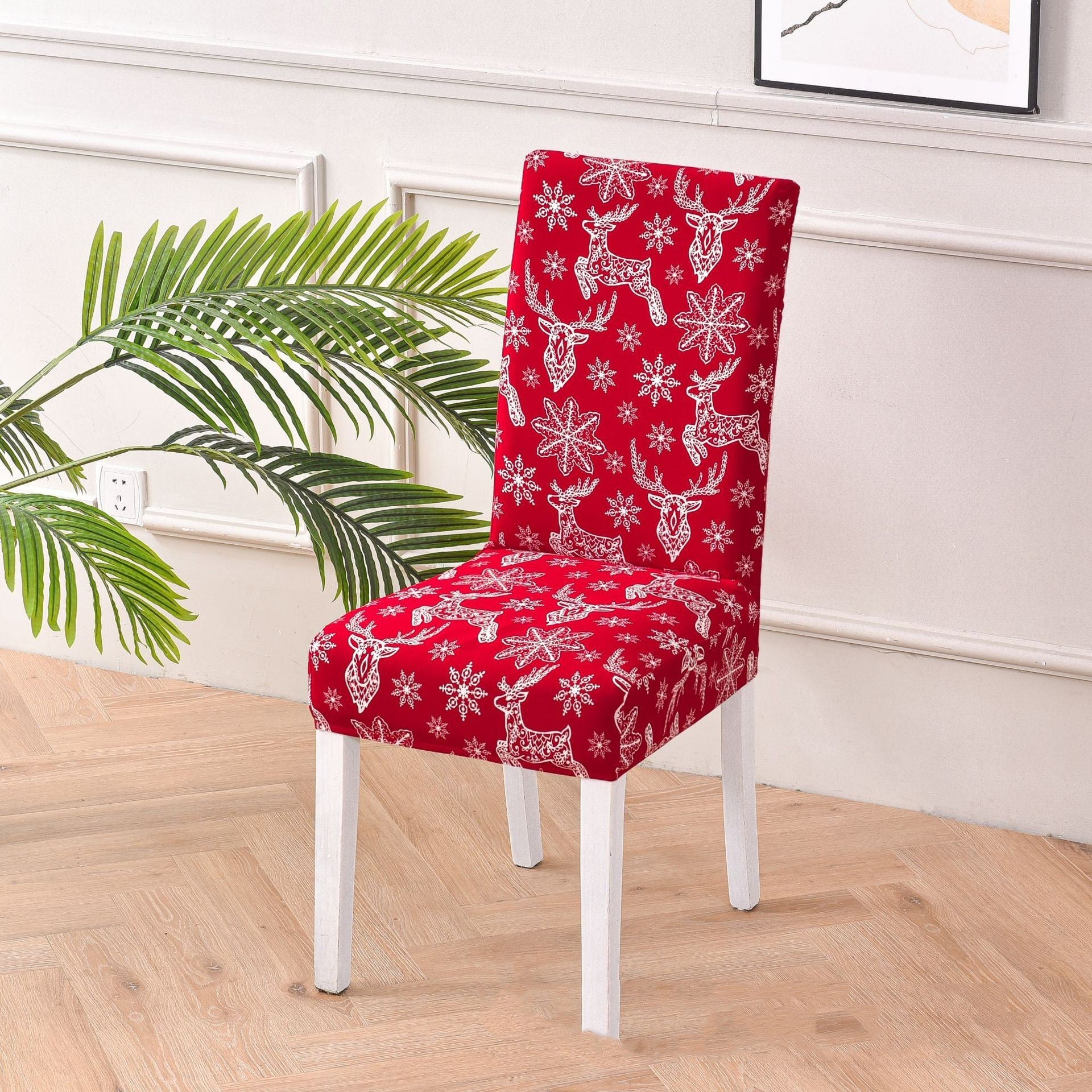 Festive red chair cover with vibrant Christmas-themed designs, including Santa Claus faces, white snowflakes, and the phrase 'Ho!' in bold white font. Features additional details like gift box illustrations with red ribbons. Snug fit for chairs with black legs, perfect for adding a cheerful holiday touch to your dining or living space. Ideal for Christmas home decorations and creating a warm, seasonal atmosphere.