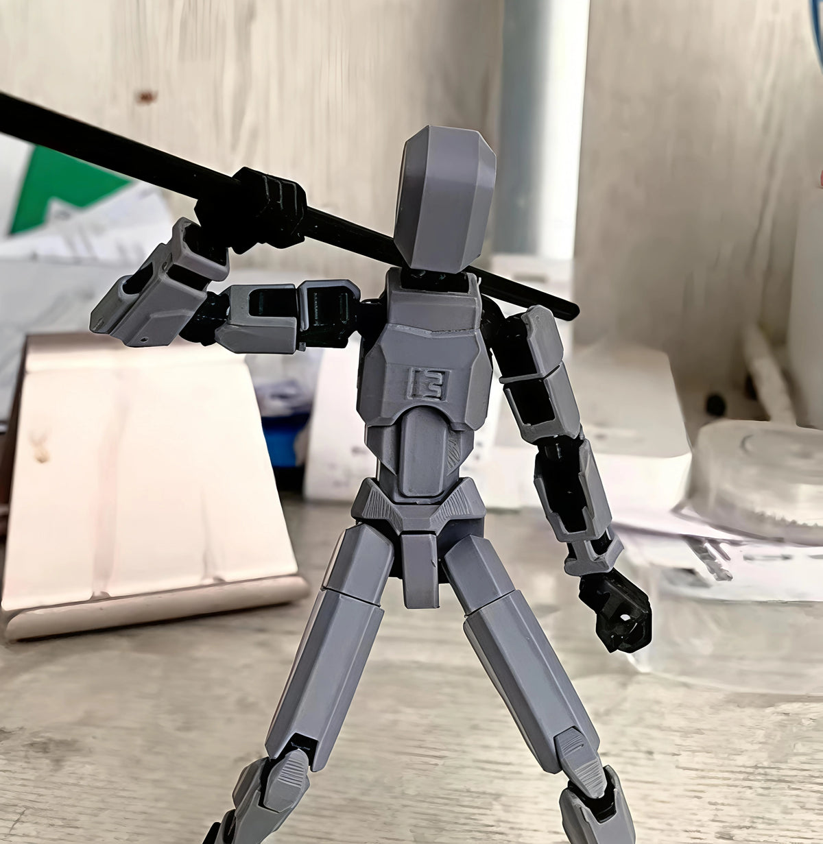 Gray robot toy with black arms on a light wooden surface