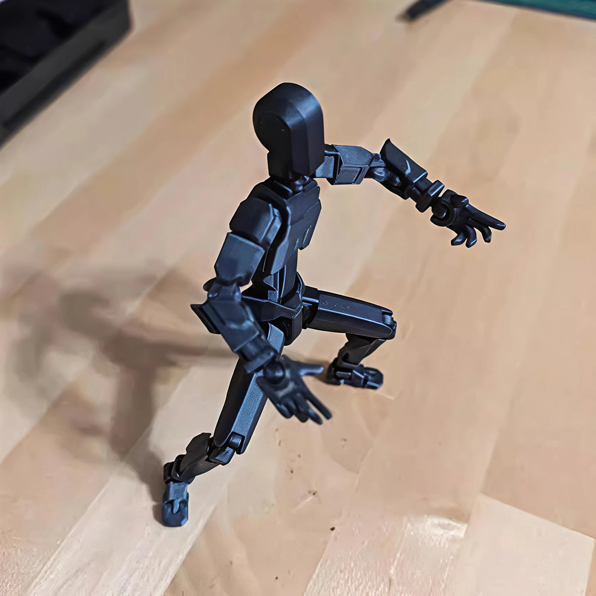 Black action figure on a wooden surface
