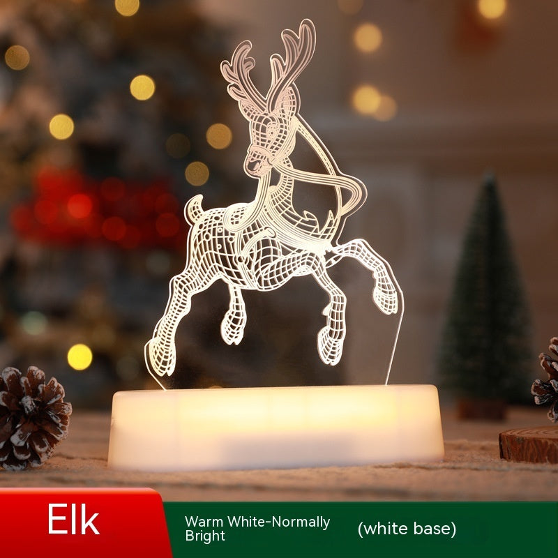 Illuminated Christmas LED lamps with a 'Merry Christmas' sign featuring reindeer antlers and a Christmas tree with presents underneath. The lamps glow warmly, set against a backdrop of a decorated Christmas tree with lights and ornaments. Pine branches and a pine cone add to the festive ambiance.