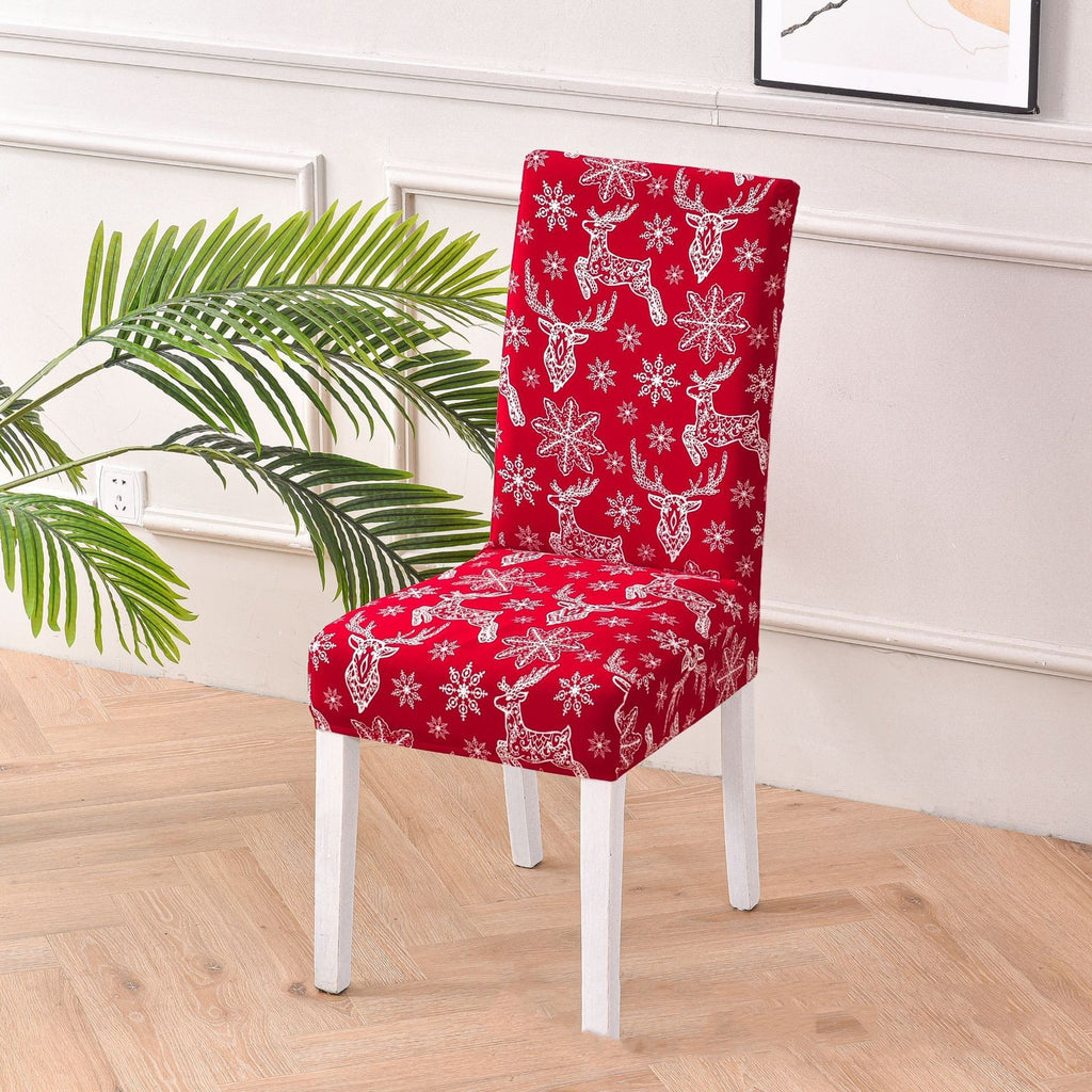 Festive red chair cover with vibrant Christmas-themed designs, including Santa Claus faces, white snowflakes, and the phrase 'Ho!' in bold white font. Features additional details like gift box illustrations with red ribbons. Snug fit for chairs with black legs, perfect for adding a cheerful holiday touch to your dining or living space. Ideal for Christmas home decorations and creating a warm, seasonal atmosphere.