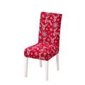 Festive red chair cover with vibrant Christmas-themed designs, including Santa Claus faces, white snowflakes, and the phrase 'Ho!' in bold white font. Features additional details like gift box illustrations with red ribbons. Snug fit for chairs with black legs, perfect for adding a cheerful holiday touch to your dining or living space. Ideal for Christmas home decorations and creating a warm, seasonal atmosphere.